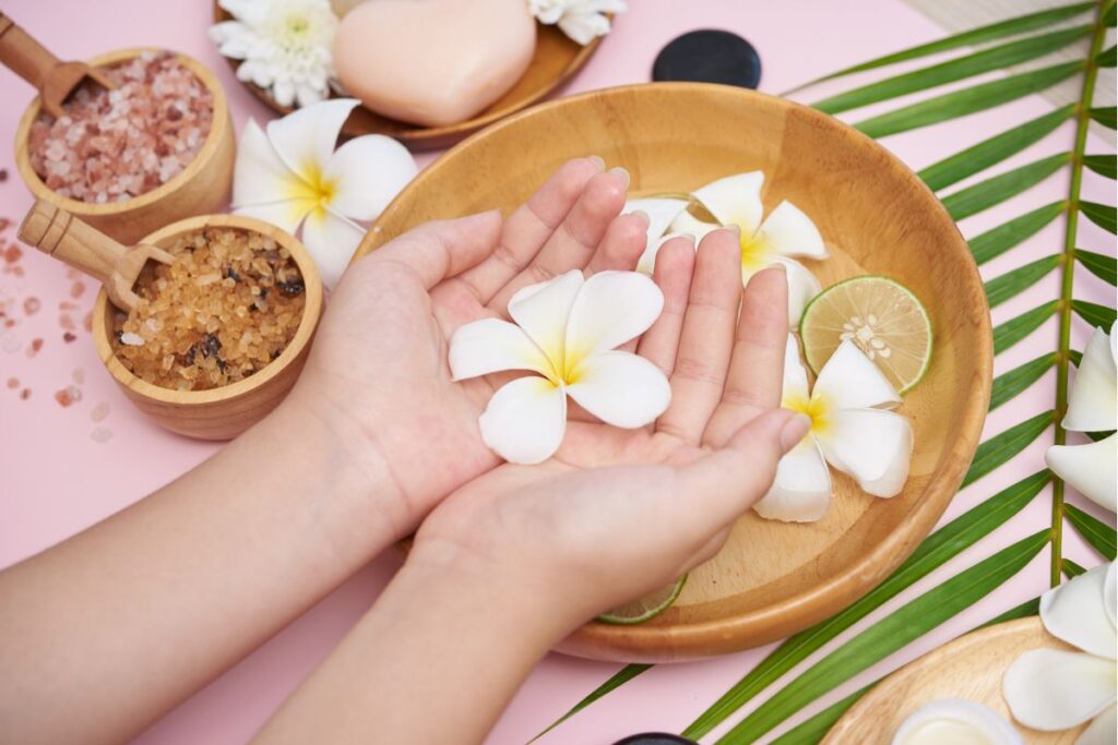 Hands in a bowl of water and flowers