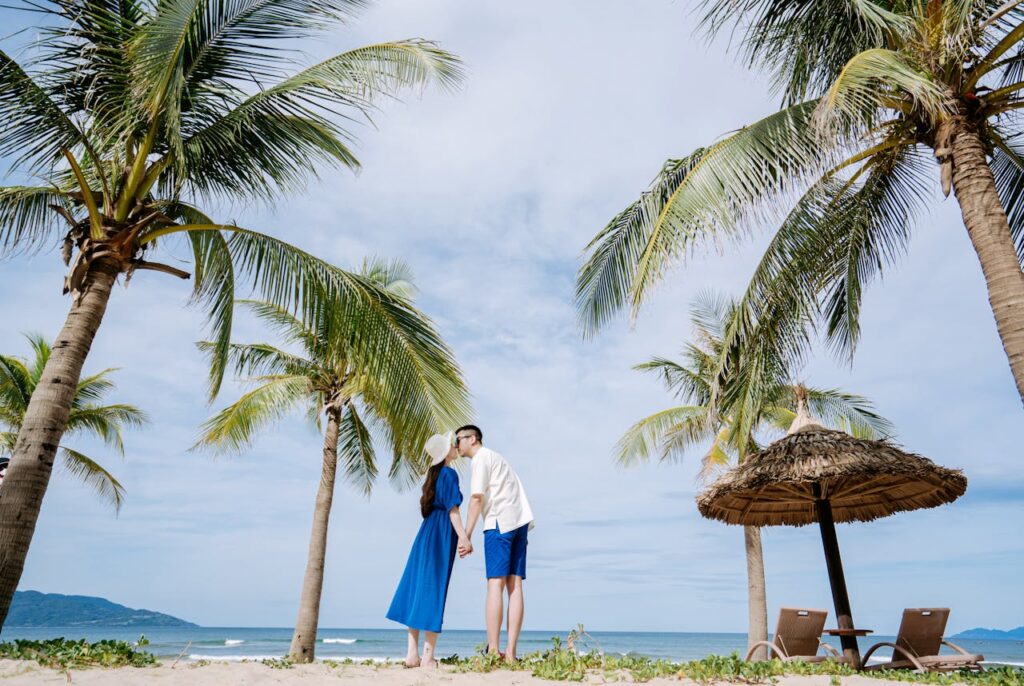 couple kissing under coconut trees