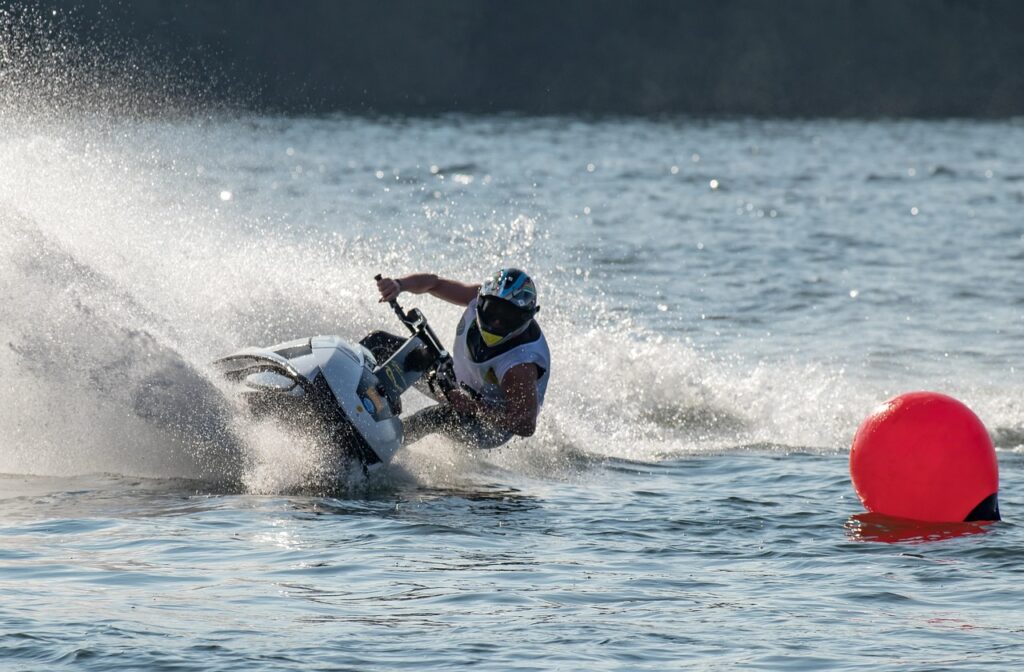 a man jet skiing at great speed making waves