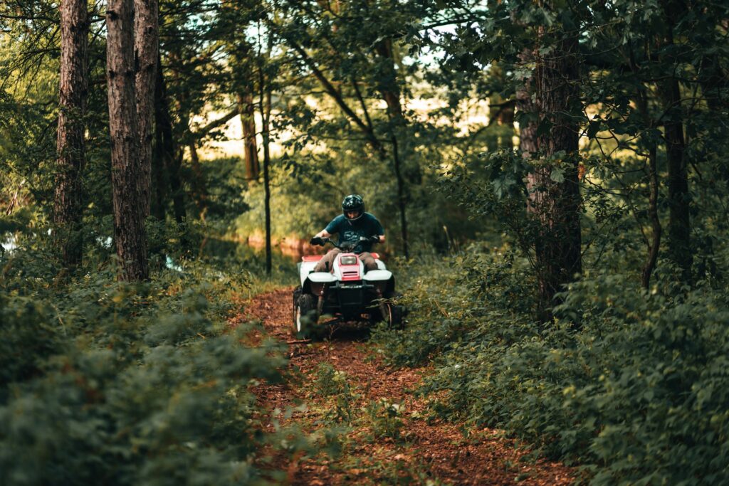 a guy riding an ATV in a forest